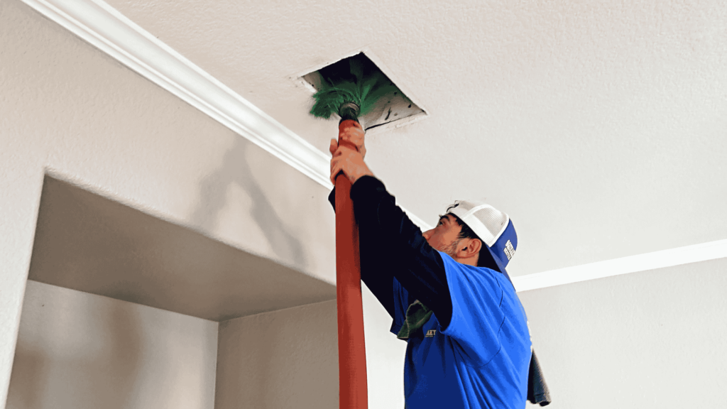 A man cleaning a celing airduct
